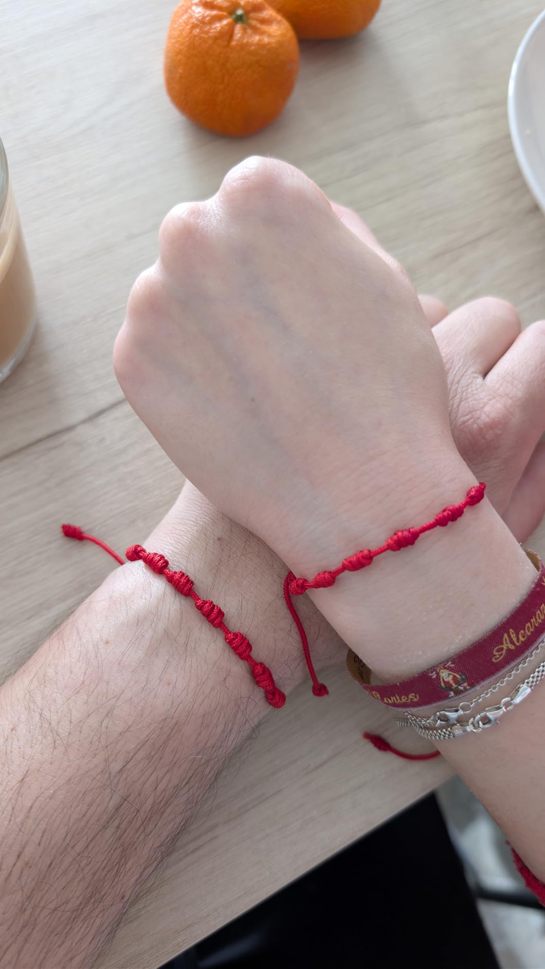 Dos pulseras rojas de 7 nudos en muñecas de clientes