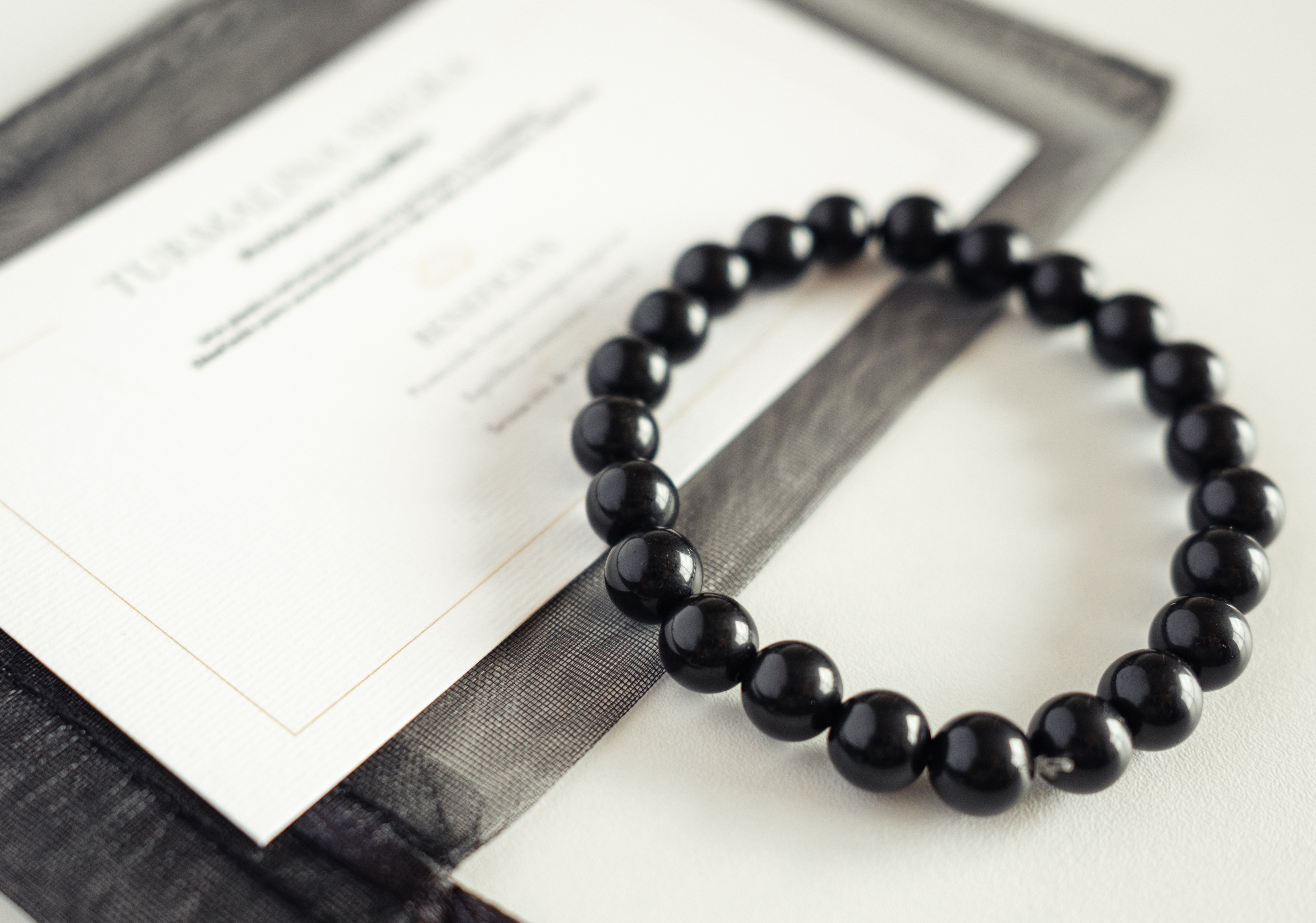Pulsera Turmalina RAIAN junto a su tarjeta explicativa